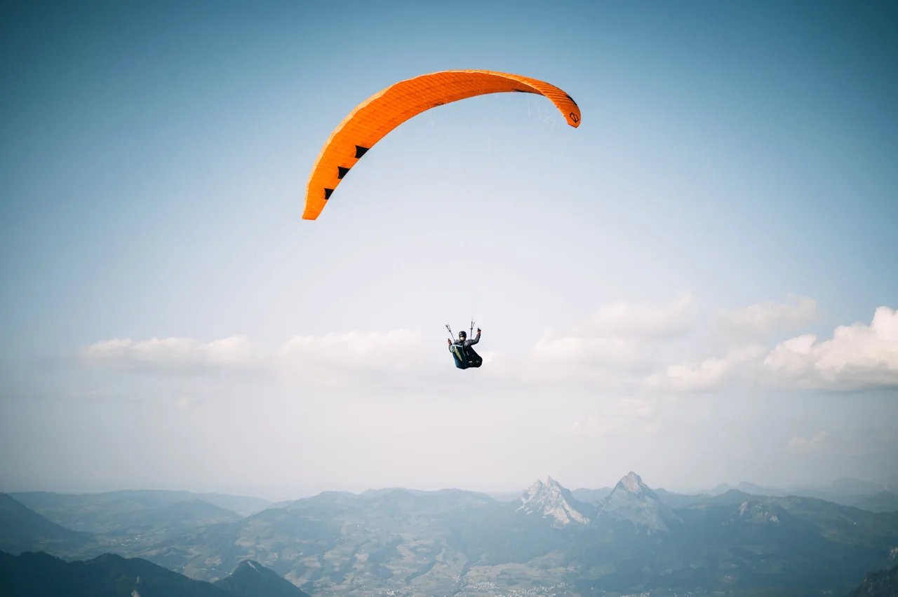 Gleitschirm orange, Air, Sportfotografie von Thomas Leuthard