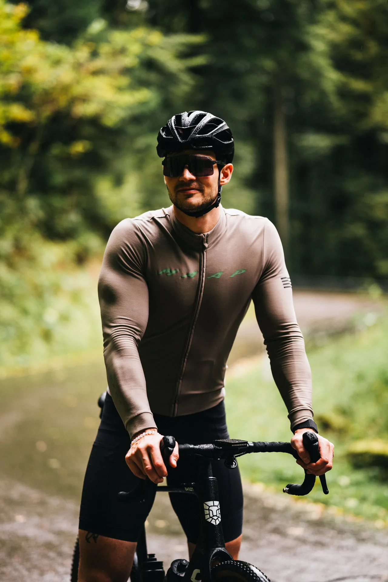 Rennradfahrer in Trikot mit Sonnenbrille im Wald